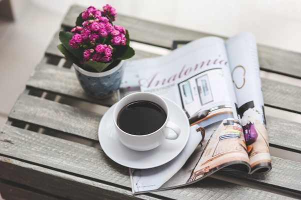 Kávé, újság és virág az asztalon