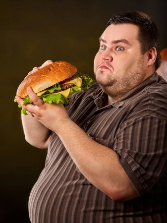 Kövér ember hamburgert eszik
