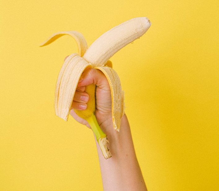 Hámozott banánt tart a kezében