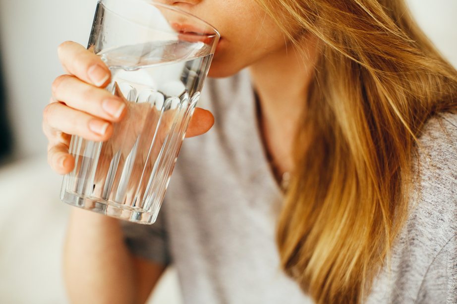 Egy nő vizet iszik pohárból